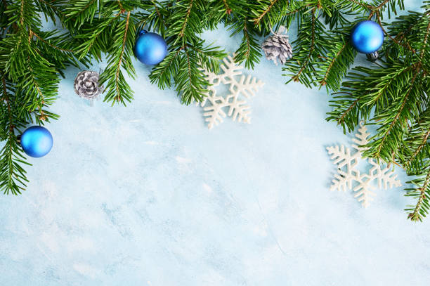 istock flat lay top view christmas tree branches frame with silver toys and fir-cones on blue background. New year holiday concepr. Text space 1251348277