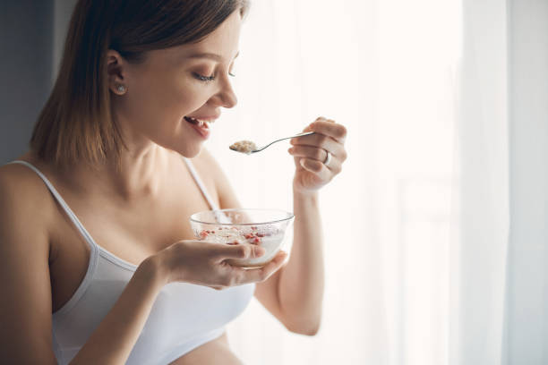 istock Pregnant woman is eating cornflake with milk 1251348432