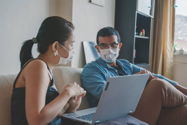 istock Talking with surgical mask, social distancing at home 1251348892