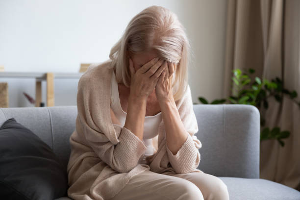 Stressed elder lady suffering from loneliness at home. Depressed older woman covering face with hands, crying, feeling desperate. Unhappy mature grandmother experiencing grief, relative’s death, bad news. Stressed elder lady suffering from loneliness. hopelessness photos stock pictures, royalty-free photos & images