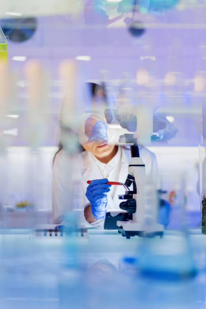 istock Female scientist during research. Using microscope in futuristic lab 1251349959