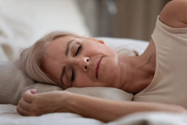 istock Serene older woman sleeping on comfortable pillow in bedroom. 1251350009