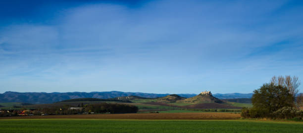 istock Panorama of fields and mountains with a castle ruin 1251350492