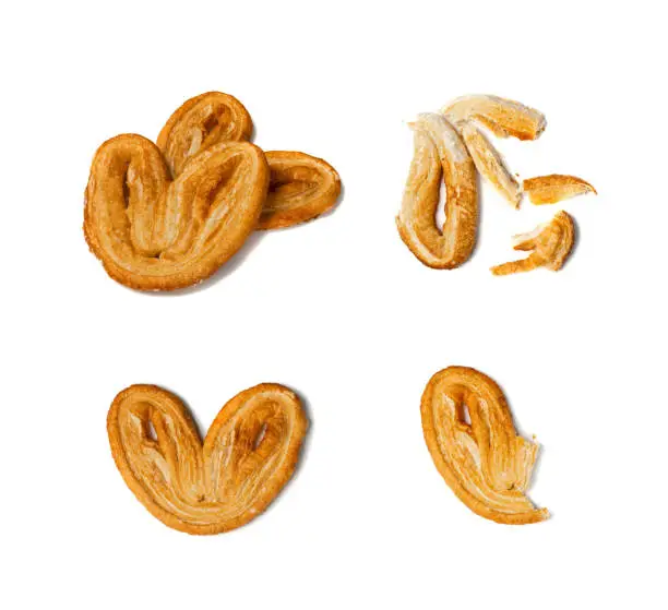 Piece of palmiers pastry, palm heart or elephant ear isolated on white background. French puff pastry or pate feuilletee bit