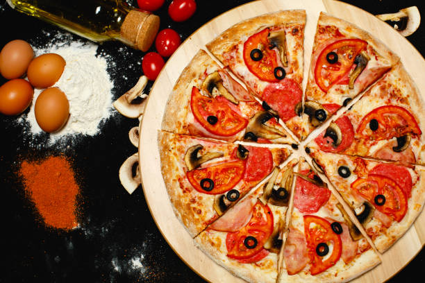 istock Pizza with ingredients on a black background. Top view. Close-up 1251352738