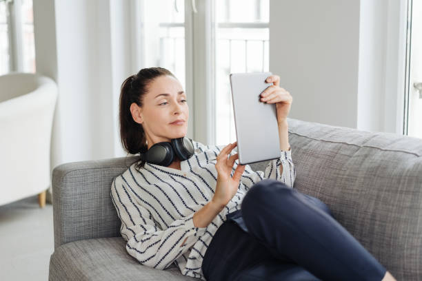 istock Young woman relaxing with a tablet computer 1251353744