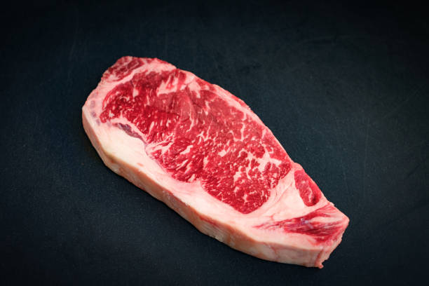 istock raw marbled beef strip loin steak on a black background 1251354128