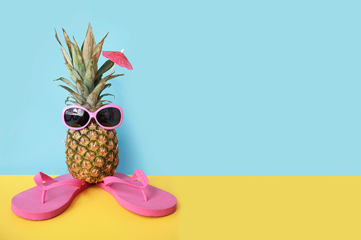 Pineapple in sunglasses and flip flops