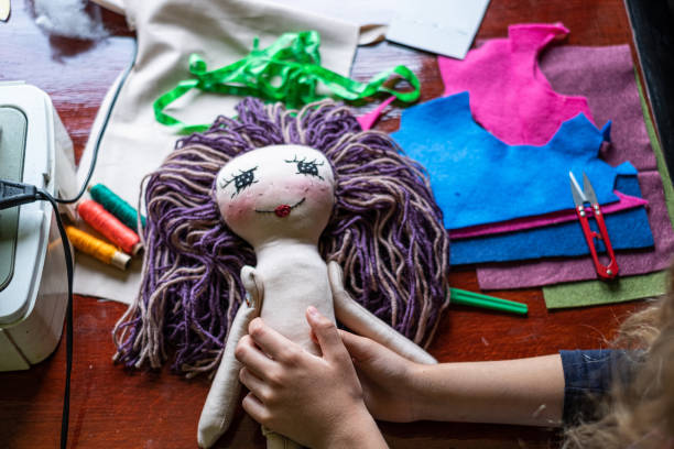 istock Human hands finishing handmade doll 1251357071