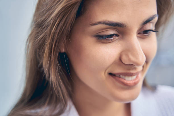 istock Charming young woman looking down and smiling 1251357175