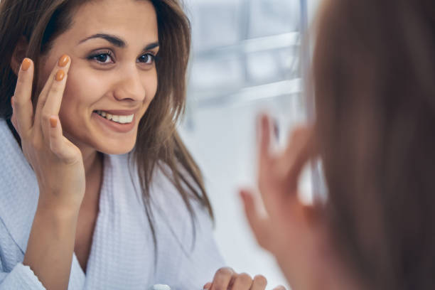 istock Charming young woman looking in the mirror in bathroom 1251357946