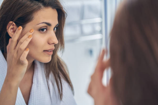 istock Pretty lady looking in the mirror in bathroom 1251357952