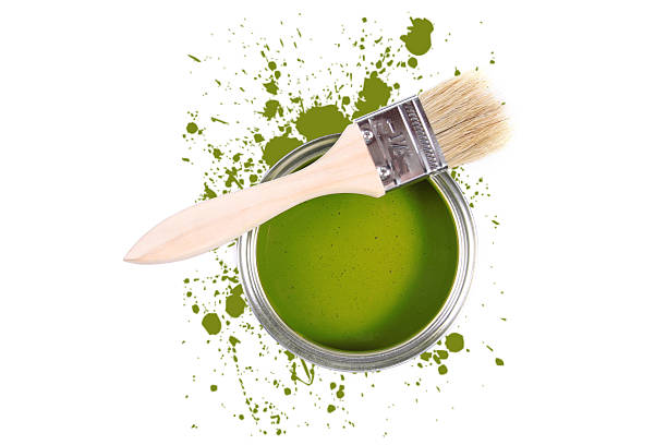Green paint brush and paint on a green background. Top view