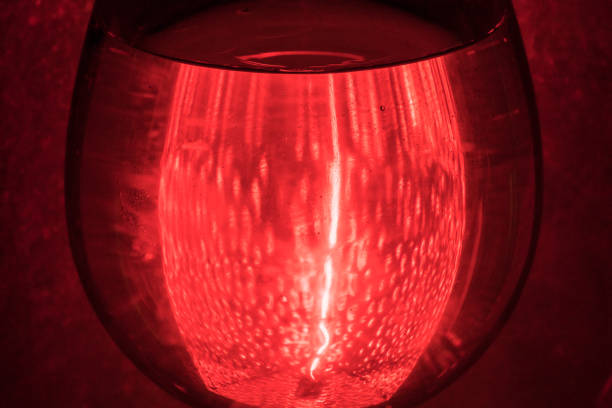 istock Glass of wine on red background 1251359342