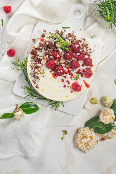 istock Cheesecake with raspberries, chocolate, hazelnuts and rosemary leaves on kitchen coutertop 1251361070