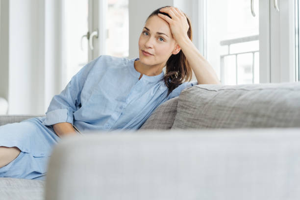 istock Thoughtful young woman relaxing on a couch 1251362559