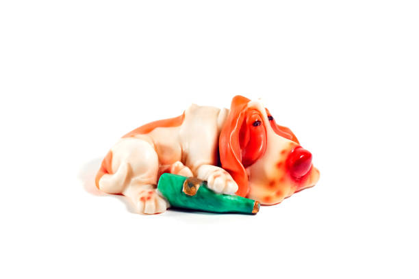 istock statuette of a sleeping dog with a bottle on a white background 1251363226