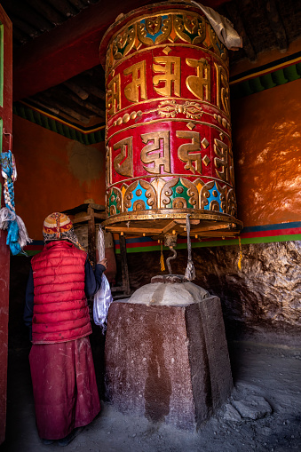 A young Tibetan Buddhist monk turning the prayer wheels, Lo Manthang in Upper Mustang. Mustang region is the former Kingdom of Lo and now part of Nepal,  in the north-central part of that country, bordering the People's Republic of China on the Tibetan plateau between the Nepalese provinces of Dolpo and Manang.
