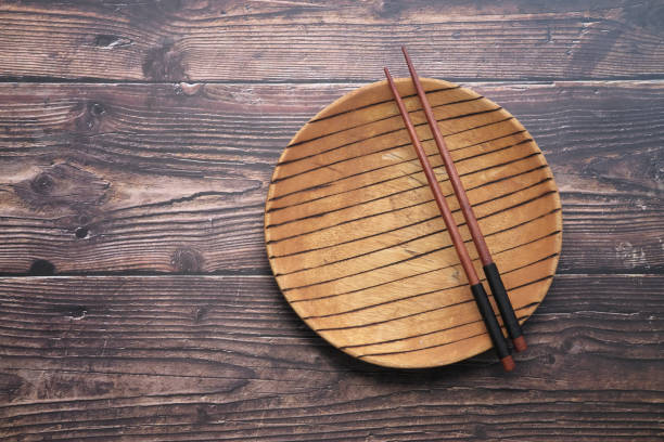 Empty plate and chopsticks on wooden Background