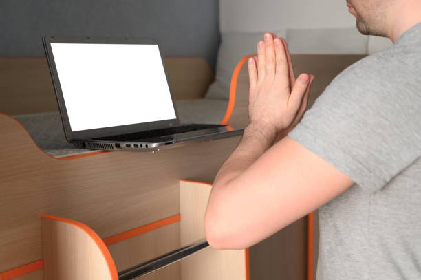 istock Young adult man stands in a tree pose while doing yoga at home. 1251367909