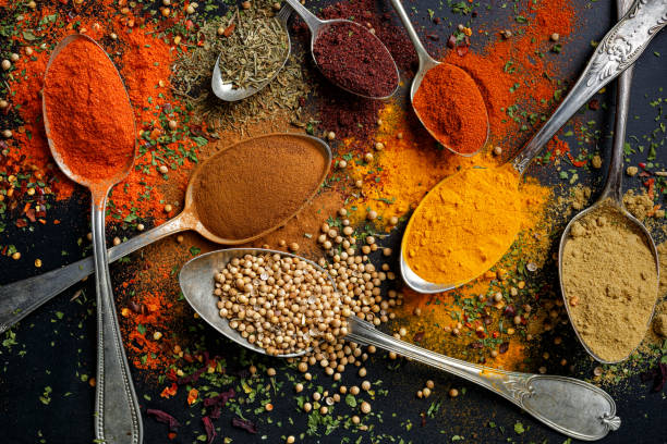 istock Various spices and herbs on spoons on a black background 1251370233