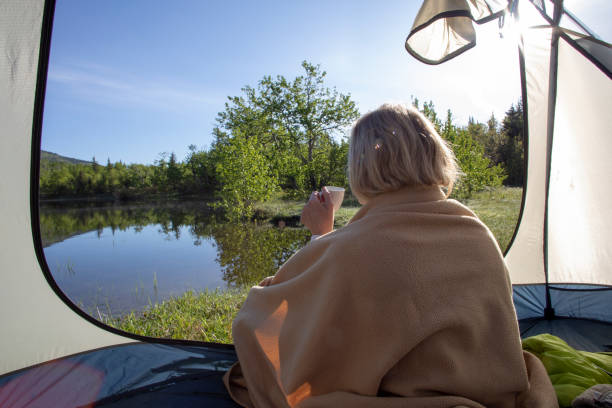 frau genießt espresso auf sonnigem campingplatz am see - lake tranquil scene landscape zen like stock-fotos und bilder