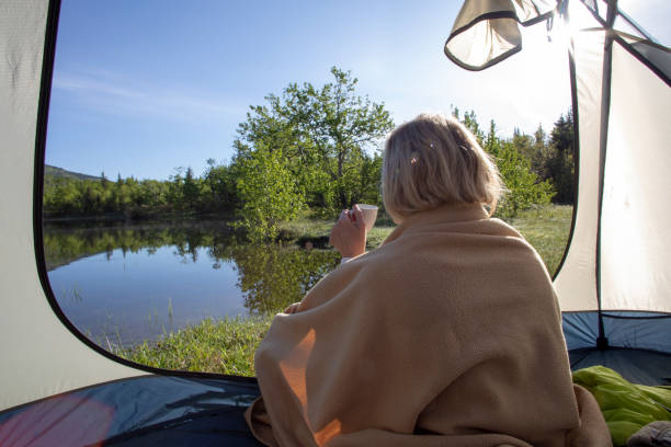 mulher desfruta de expresso em acampamento ensolarado à beira do lago - lake tranquil scene landscape zen like - fotografias e filmes do acervo