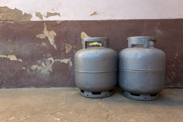 Pair of gas next to a old wall Spare gas canisters on a small farm canister stock pictures, royalty-free photos & images