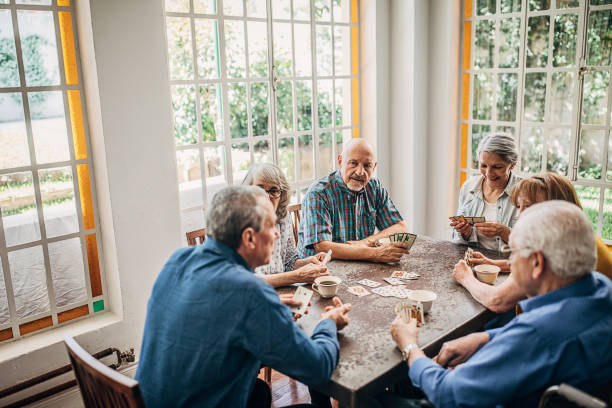 istock Senior friends having fun playing cards 1251373696