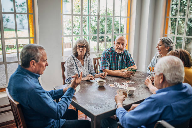 istock Senior friends having fun playing cards 1251373762