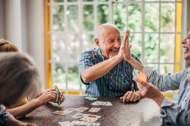 istock Senior friends having fun playing cards 1251373815