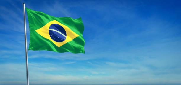 The National flag of Brazil The National flag of Brazil blowing in the wind in front of a clear blue sky national anthem stock pictures, royalty-free photos & images