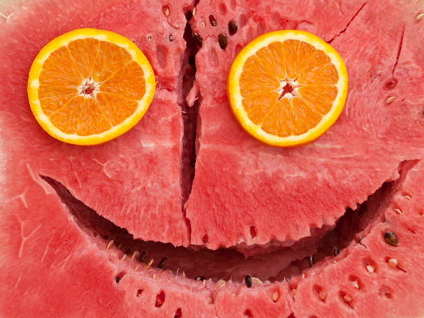 Funny face made from ripe watermelon and two round slices of orange