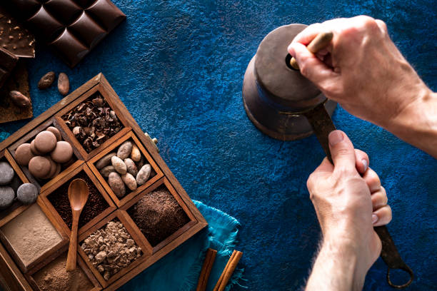 istock Chocolate pot copper grinding cocoa with hands holding stick with assorted chocolate box 1251376615