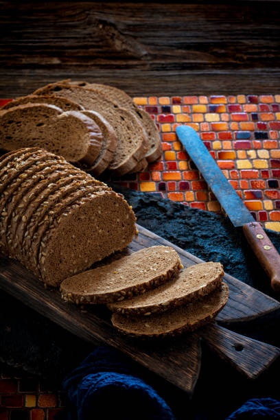 Wholegrain rye bread loaf on cutting board with vintage knife