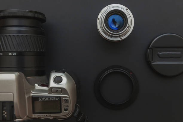 istock Photographer workplace with dslr camera system and lens on dark black table background. Hobby travel photography concept. Flat lay top view copy space 1251379427
