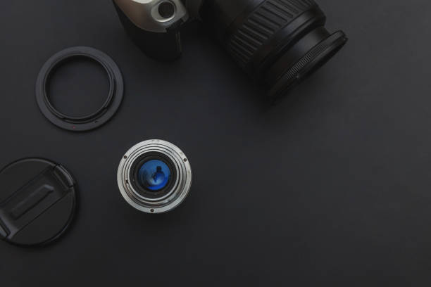 istock Photographer workplace with dslr camera system and lens on dark black table background. Hobby travel photography concept. Flat lay top view copy space 1251379461