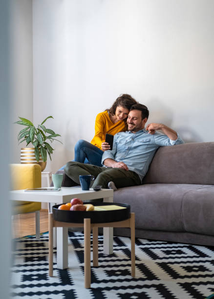 istock Couple using mobile phone at home stock photo 1251382180