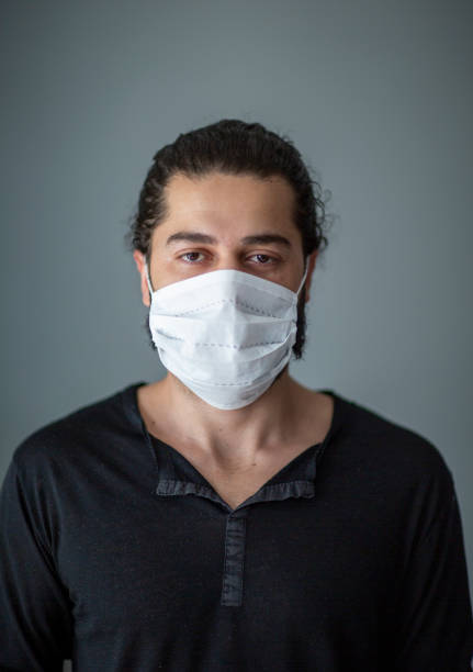 istock Man With Protective Face Mask Breaking Cigarette After COVID-19, Quit Smoking Concept 1251382328