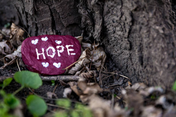 A maroon painted rock, that says, \