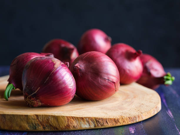 red onions on wood board - spanish onion imagens e fotografias de stock