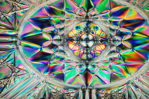 Abstract multicolored refractions of a plastic bowl photographed under polarized light.