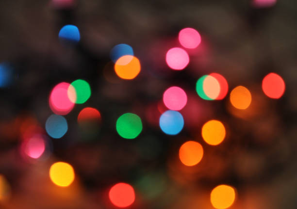 istock Glowing and festive colored light circles created from in camera and lens bokeh. Christmas fairy lights defocused giving a blurred effect. Background for design. 1251388524