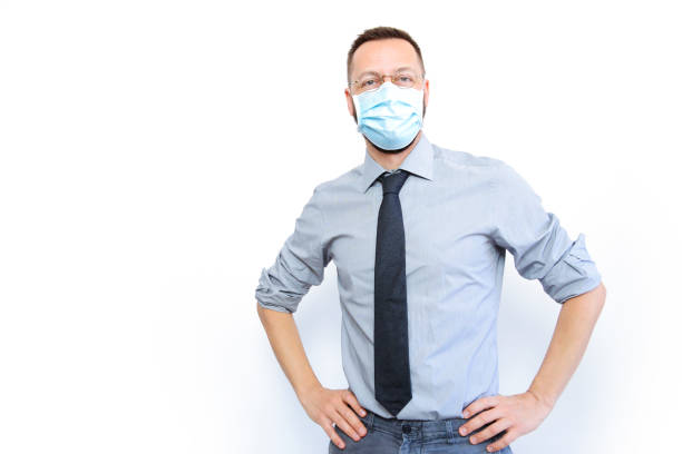 A young business man smiling behind the mask stock photo