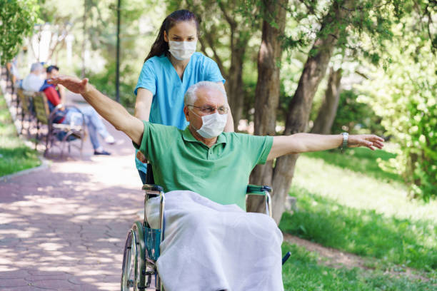 Young female nurse with disabled in the garden Young female nurse with disabled in the garden walking aide stock pictures, royalty-free photos & images