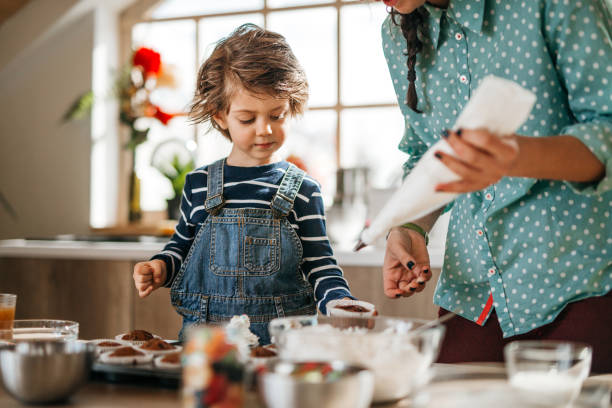 istock Mother and son making birthday muffins. 1251393619