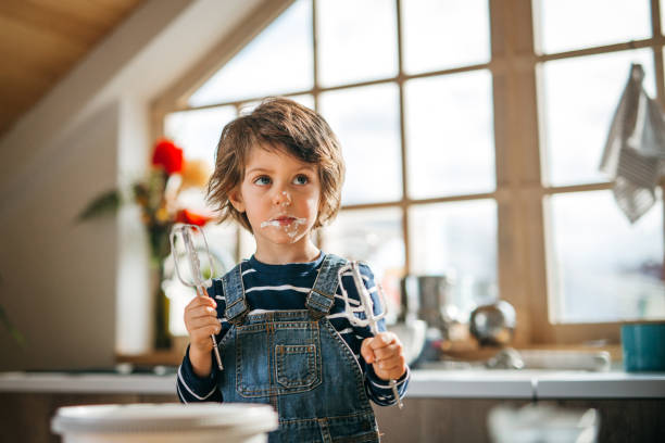 istock Little assistant tasting whipped cream and making funny faces. 1251393654