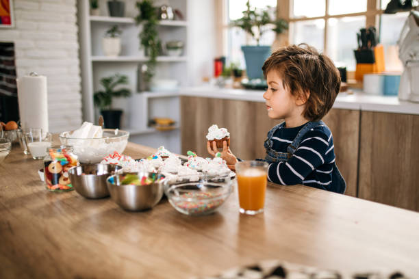 istock Little blonde boy tasting muffins in the kitchen. 1251393891