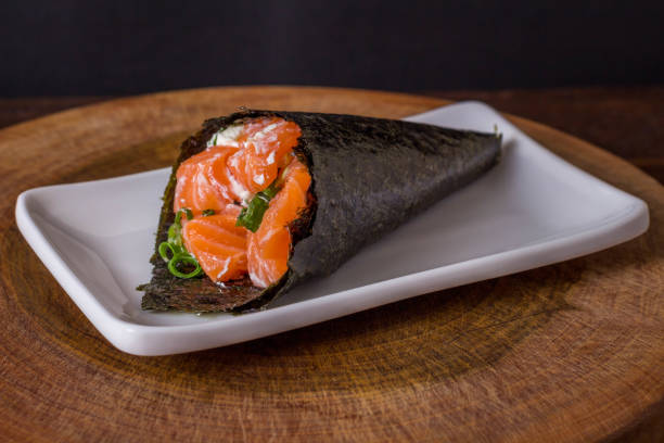 суши из лосося темаки на белой тарелке на черном фоне - temaki food sushi salmon стоковые фото и изображения