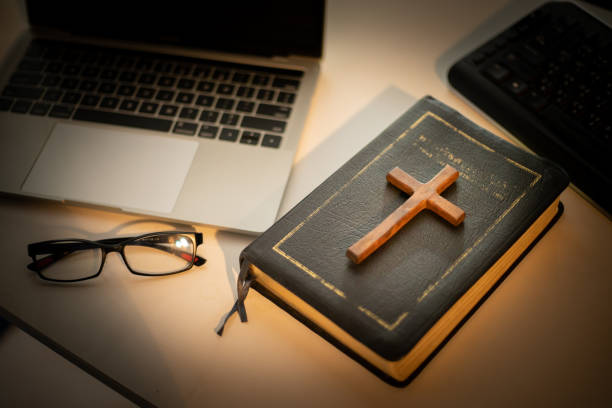 istock Cross over wood table with window light. online church concept. 1251402095